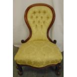 A Victorian spoon back upholstered salon chair with carved hardwood frame and button back