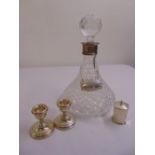 A pair of silver dwarf candlesticks, a silver pepperette and a ships decanter with silver collar and