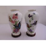 A pair of ceramic ovoid vases The Caribbean Butterfly by John Wilkinson on circular wooden stands