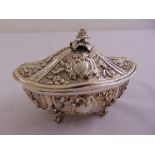 A continental white metal shaped oval box and cover leaf and scroll chased sides on leaf scroll