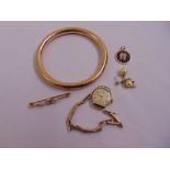 A quantity of gold to include a 15ct bar brooch set with amethyst and seed pearls, a 9ct bangle, a