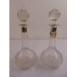 A pair of cut glass decanters with silver collars and drop stoppers, A/F