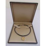 A Bulgari steel and 18ct gold Tondo pendant on a leather necklace, in original box