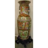 A 20th century Cantonese vase profusely decorated with flowers leaves and figures on carved hardwood