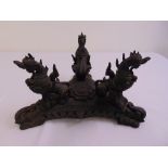 An oriental hardwood carved centre piece in the form of dragons and stylised elephant on triform