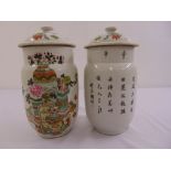 A pair of famille rose ginger jars, cylindrical decorated with flowers, vases and Chinese characters