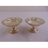 A pair of silver circular pierced bonbon dishes on raised circular bases, Birmingham 1910