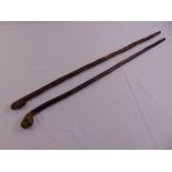 Two oriental bamboo walking sticks with carved mask handles