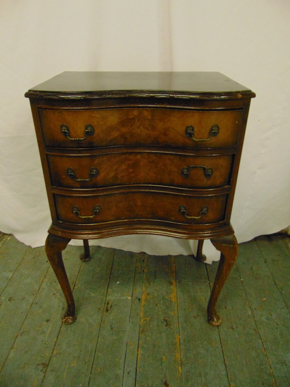 A mahogany shaped rectangular chest of drawers on four cabriole legs