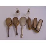 A silver dressing table set to include five brushes, a hand mirror and two cut glass scent bottles