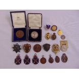 A quantity of medals and badges cast in various medium to include Rifle Club medals, two in original