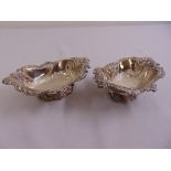 A pair of silver shaped oval bonbon dishes on raised oval bases, London 1909