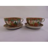 A pair of Chinese famille rose tea cups and saucers