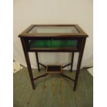 A mahogany and glass rectangular display case on four tapering rectangular legs