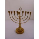 A brass Menorah of customary form on stepped octagonal base