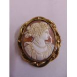 A Victorian carved cameo of a classical maiden set in pinchbeck frame with a locket of hair to the