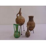 Three Byzantine terracotta vases, two mounted on metal stands and a two handled glass vase