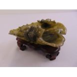 A Chinese jadeite carved dish in the form of a leaf on raised hardwood stand