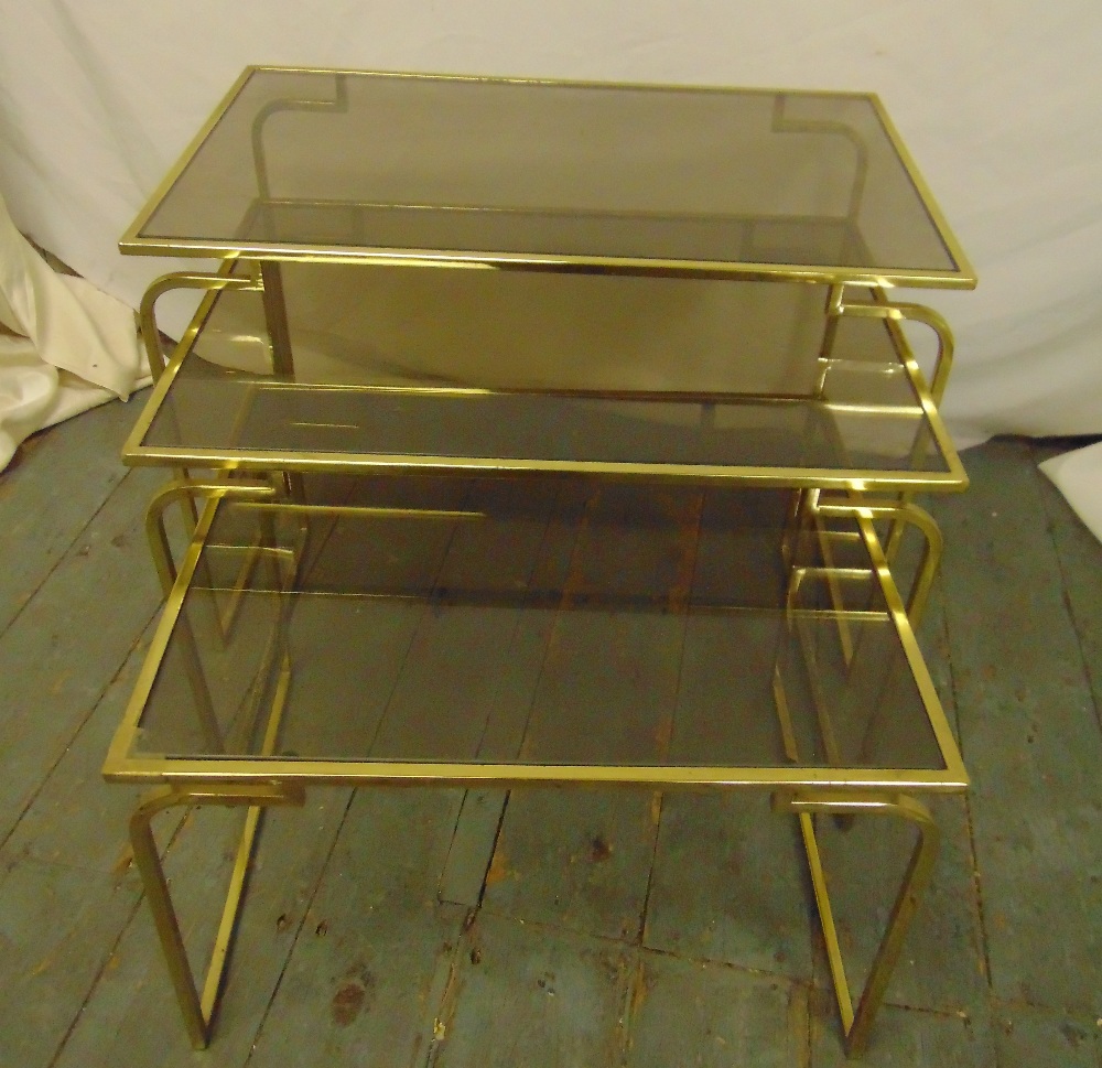 A gilt metal and glass nest of three rectangular tables