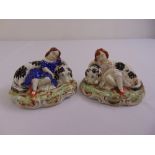 A pair of Staffordshire ceramic figurines of young ladies with dogs