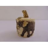 An early 20th century oriental ivory cylindrical box carved to the sides with elephants and