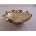 A silver circular nut dish with scroll pierced sides on raised circular base, Sheffield 1958 by