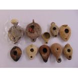 Ten Roman and Greek antique terracotta oil lamps of various shape and size