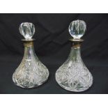 A pair of ships decanters with drop stoppers and silver collars