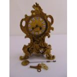 A French gilded metal Rococo style mantle clock, to include pendulum and key