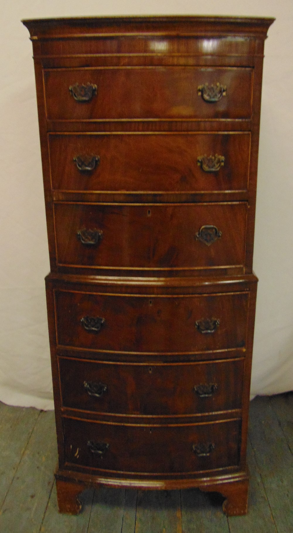 A mahogany tallboy rectangular bow fronted with six drawers, brass swing handles, on bracket feet