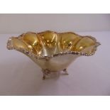 A continental white metal fruit bowl, lobed sides, leaf and scroll border on three scroll feet