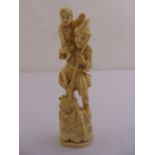 A late 19th century Japanese ivory figurine of a man carrying a child