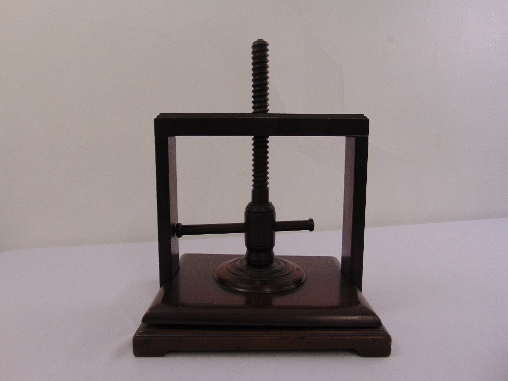 A Victorian mahogany book press of customary form on rectangular base with bracket feet