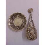 A Chinese white metal pendant on chain and a pin tray inset with a coin