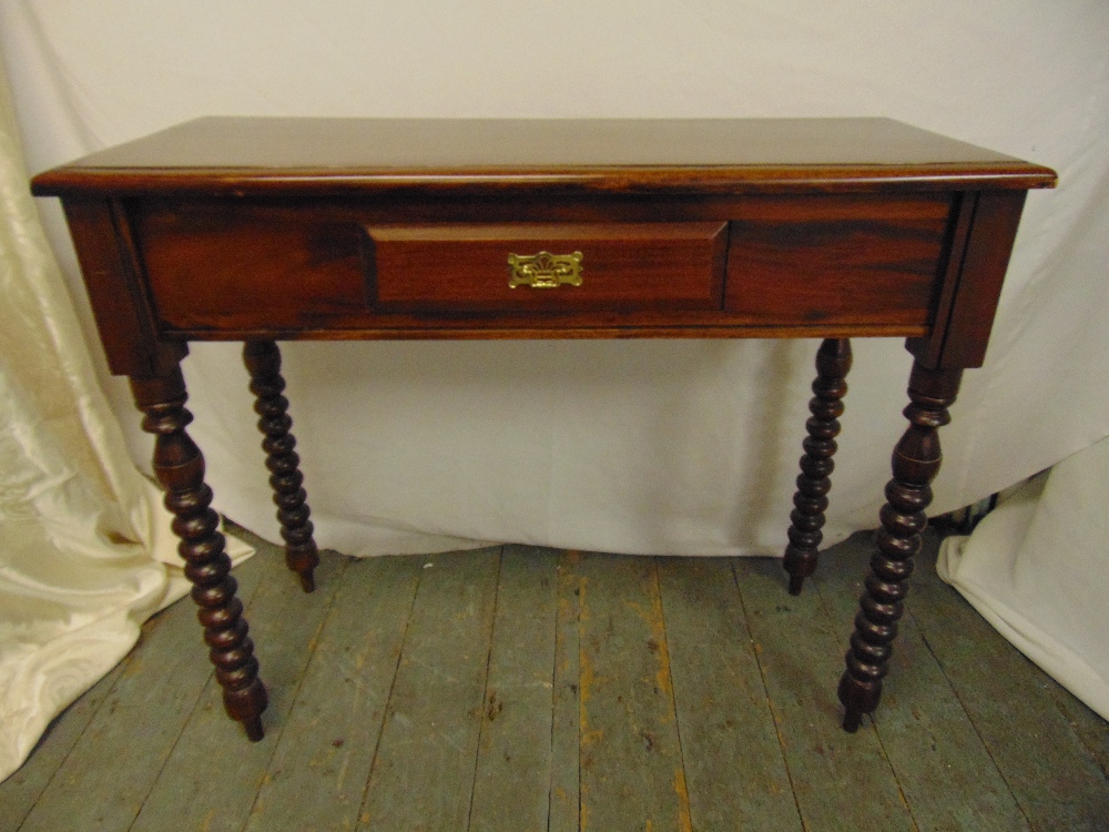 A mahogany rectangular hall table on four turned legs the single drawer with brass swing handle