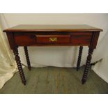 A mahogany rectangular hall table on four turned legs the single drawer with brass swing handle