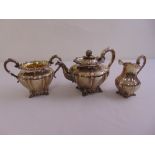 A Victorian silver three piece teaset, circular lobed form, heavy scroll borders, leaf capped scroll