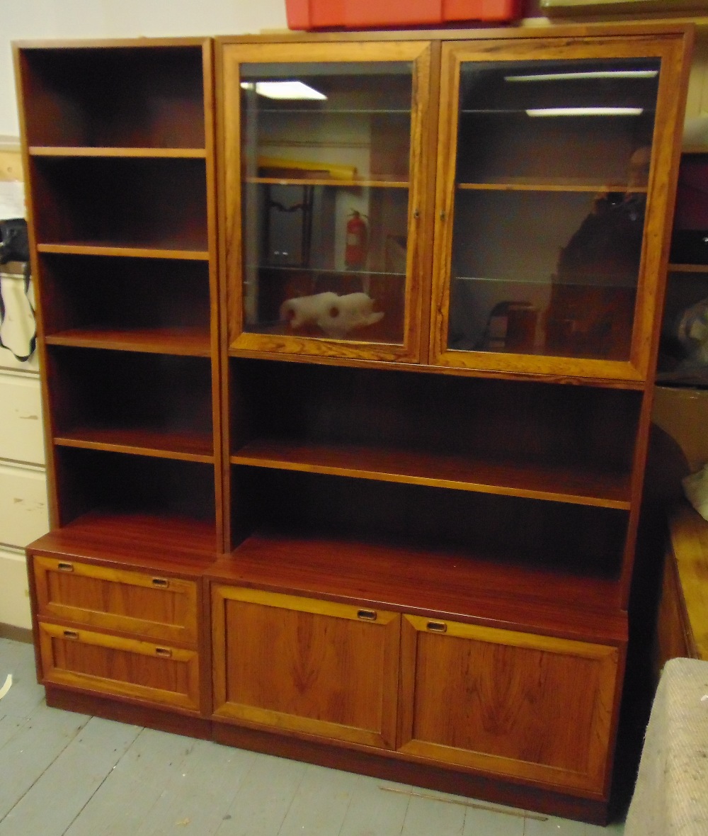 A late 20th century Danish rosewood wall unit comprising hinged glazed doors, shelves and