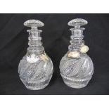 A pair of Georgian style cut glass decanters with drop stoppers and four hallmarked silver wine