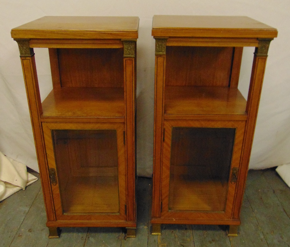 A pair of rectangular satinwood Biedermeier style cabinets with gilt mounts and hinged glazed doors
