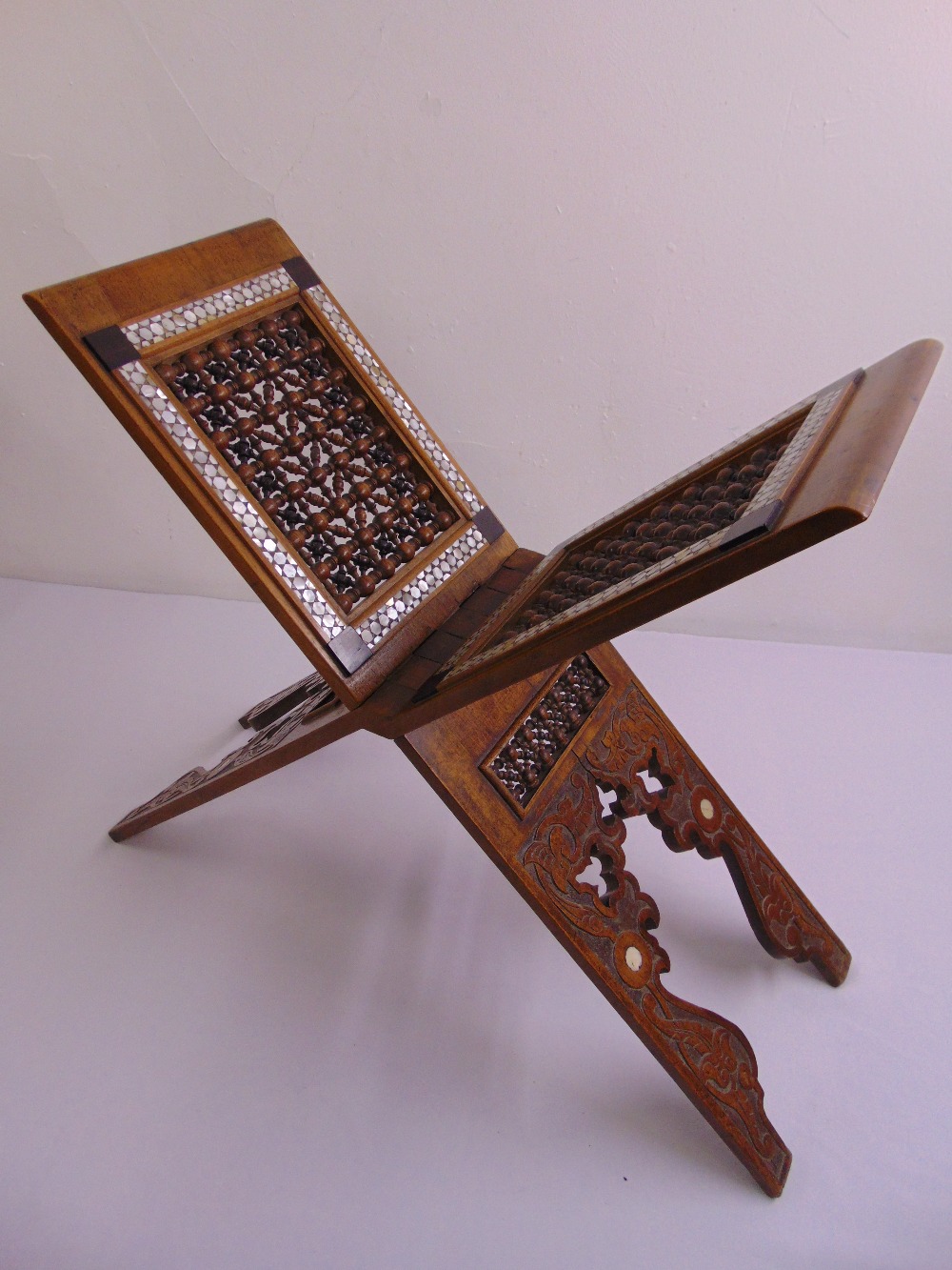 A 19th century Ottoman mahogany Koran stand with carved and pierced decoration and inlaid mother