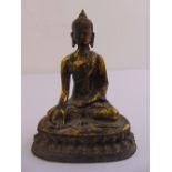 A Chinese gilded bronze figurine of Buddha on shaped oval base