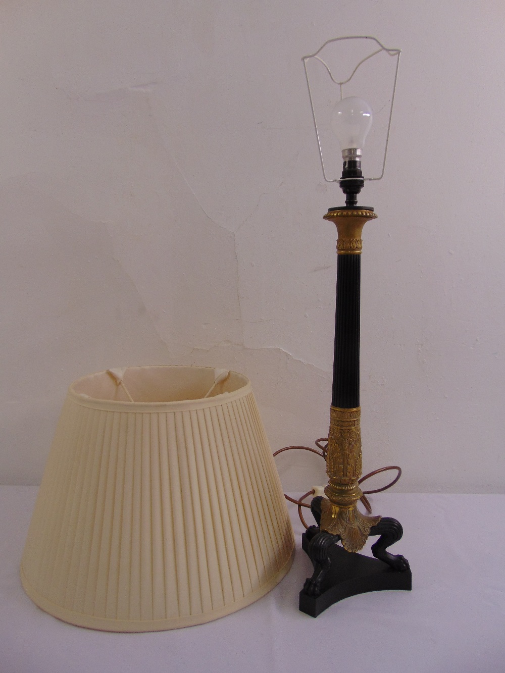 A bronze and ormolu classical style table lamp on triform base with silk shade