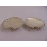 A pair of circular silver bonbon dishes scroll pierced sides on raised circular bases