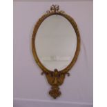 An oval neo-classical style gilded metal bevelled edge wall mirror