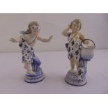 A pair of KPM figurines of putti on raised circular bases, marks to the bases