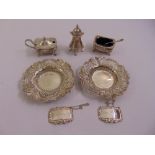 A quantity of silver to include two bonbon dishes, a three piece condiment set and two wine labels
