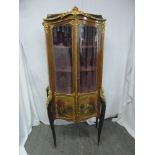 A French Vernis Martin shaped oval glazed display cabinet with gilded metal mounts and panels