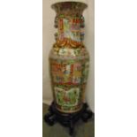 A Cantonese vase profusely decorated with flowers leaves and figures on carved hardwood stand, 133.