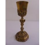 A 19th century silver gilt chalice, the triform knopped stem chased with leaves and scrolls, the